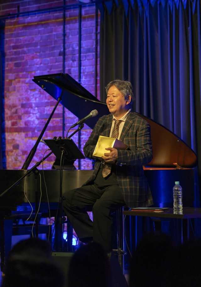 番号が書かれた紙を取り出すタケカワさん（撮影：sono）