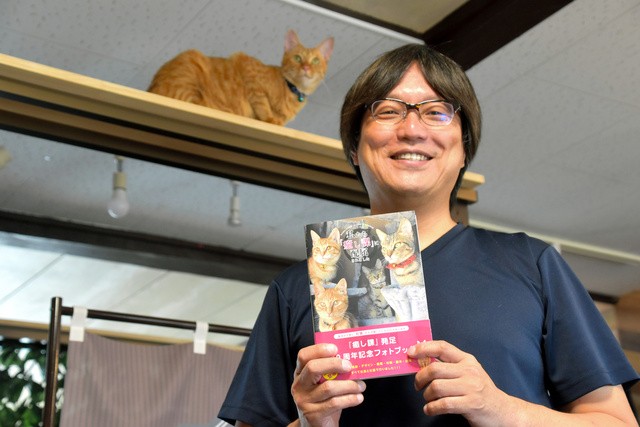 フォトブック「私たち『癒し課』に配属されました」を持つしまや出版の小早川真樹さん=2021年8月27日、東京都足立区宮城2丁目、塩入彩撮影