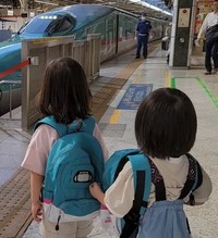 はやぶさの先頭部分が見える場所で見学する子どもたち。新幹線好きが伝わる装いでホームへ向かった／MOEさん（@hoppe.mochimochi）提供＝画像をトリミングしています