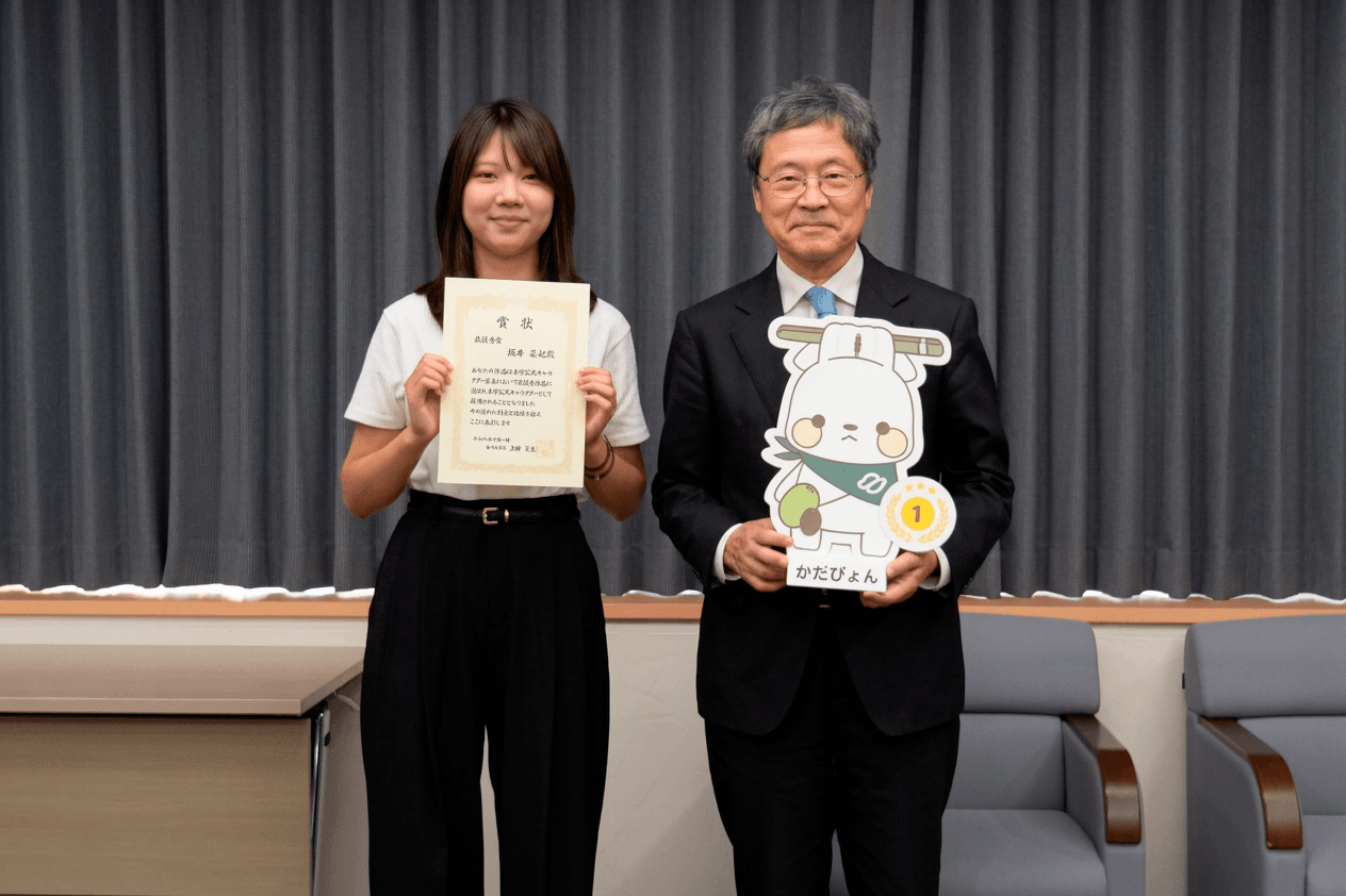 キャラクターをデザインした坂井さんと上田夏生学長