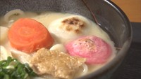 中身には、白みその出汁に、うどん、ニンジン、大根、油あげ、ネギ。そして表面を焼いた赤と白の紅白のおもちが