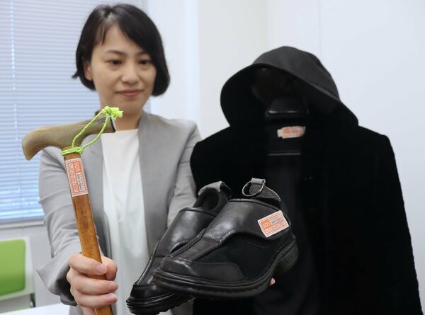 認知症で行方不明になる可能性のある人の家族に配布されるステッカー。オレンジ色でフリーダイヤルなどが記載され、つえや靴などに貼り付けてもらう（市役所）