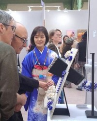 清水さんが作る万華鏡。横から見ると黒い筒の先に、青い花飾り（右端）がつるされている。２月にパリの美術展へ出展した（本人提供）
