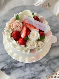 息子さんの彼女の誕生日に作った米粉シフォンのデコレーションケーキ。白やピンクのバラ、イチゴが華やかに飾られている／癒やシフォンさん（@iyachiffon）提供