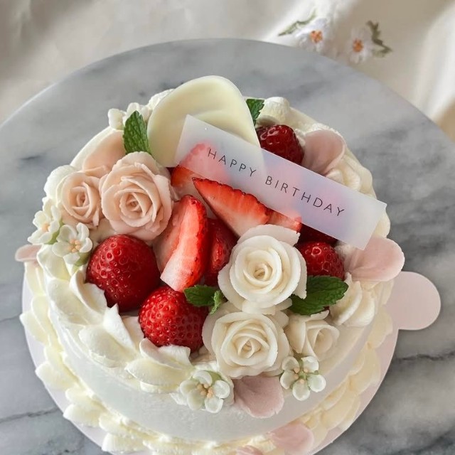 息子さんの彼女の誕生日に作った米粉シフォンのデコレーションケーキ。白やピンクのバラ、イチゴが華やかに飾られている／癒やシフォンさん（@iyachiffon）提供