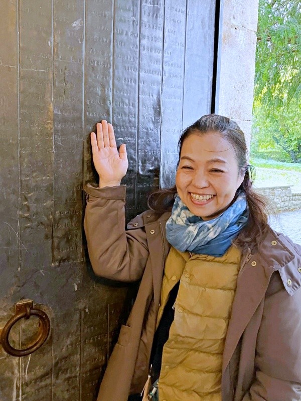 30年越しの夢を実現。刻まれた「YASUKO」の文字の前で笑みを浮かべるタカハシさん（画像提供：タカハシ ヤスコさん）