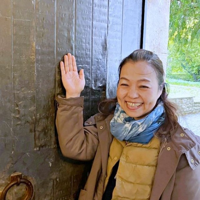 30年越しの夢を実現。刻まれた「YASUKO」の文字の前で笑みを浮かべるタカハシさん（画像提供：タカハシ ヤスコさん）