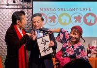 〝菅元首相そっくりさん芸人〟のドラQ(中央)にツッコミを入れるアントニオ小猪木(左)と浜田ブリトニー＝東京・浅草の「漫画ギャラリーCAFEオカオカ」