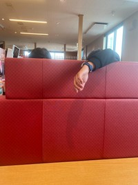 隣の席からにゅっと手が突き出ています（yuyuさんthreadsより）
