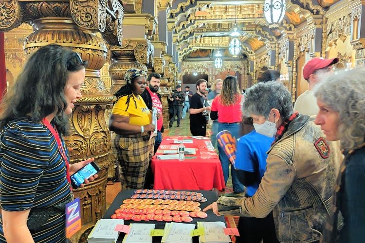 マムダニ氏の集会で支援の缶バッジを選ぶ人たち=2025年10月、ニューヨーク、福田宏樹