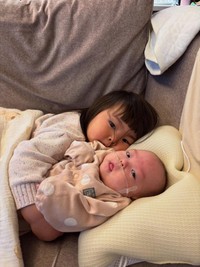 ソファで並んで寝転ぶ姉妹。少しずつ距離を縮めていく様子が微笑ましい／sayakaさん（@syk.71）提供