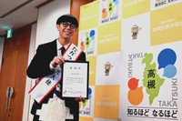 委嘱状を手に笑顔を見せるSOーSOさん