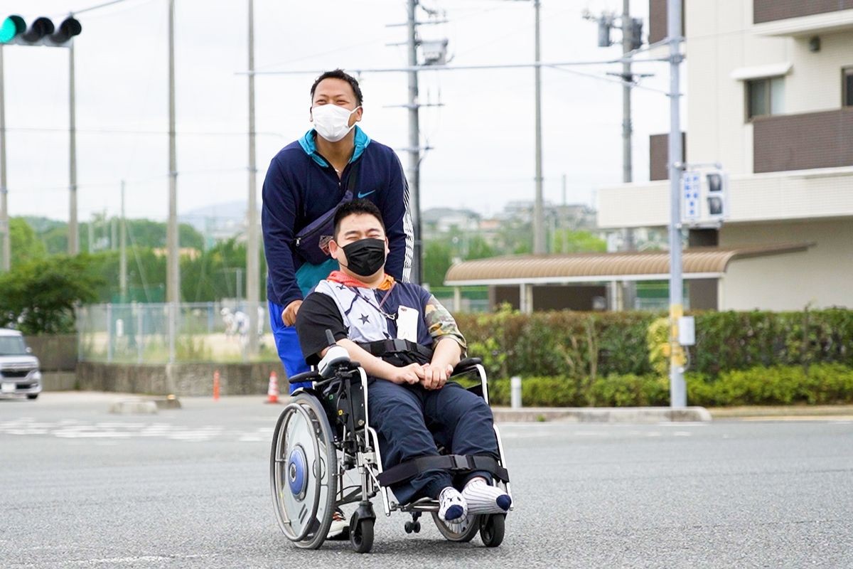 利用者と外出する職員（提供写真）