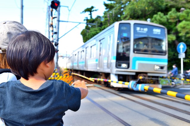 踏切で電車に手を振る親子　※画像はイメージです（masyok/stock.adobe.com）