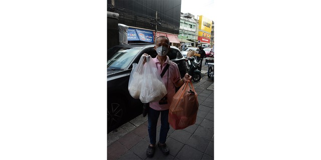 子どものころからカオニャオ・マムアンをよく買いに来たというアムナト・ルアンロチャナピブンさん。この日は同僚へのお土産にカオニャオを３．５キロ買った＝４日、バンコク、翁長忠雄