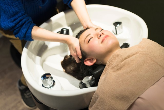 美容室でシャンプーしてもらう女性　※写真はイメージ（One/stock.adobe.com）