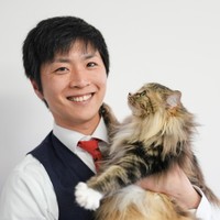 看板猫のいぐさを抱っこする鶴上さん。「猫と人が幸せに暮らせる住環境を整えたい」