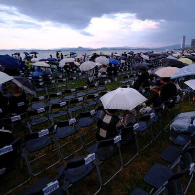 昨年の花火大会直前、降り出した大粒の雨に傘をさすなどする人たち（２０２５年８月８日午後６時４１分、大津市島の関）