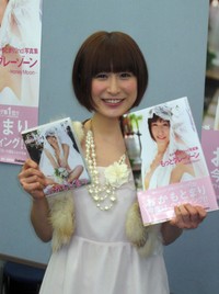 2011年１月、グラビアアイドルとして自身の写真集を手にする当時21歳のおかもとまり＝東京・秋葉原