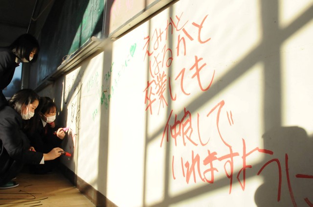思い出のある校舎で、友達や学校生活の思い出をメッセージに込める生徒（京都府向日市・京都西山高）