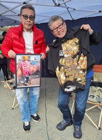 トークショーで関係者から贈られたアロハシャツを手にする布川敏和（右）。左は井上ケイ氏＝神奈川県・茅ヶ崎中央公園