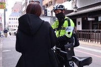 一時不停止の疑いがあるとして自転車利用者に声をかける隊員（７日、中京区室町通姉小路下ル）
