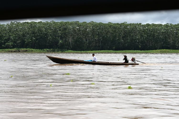 木製ボートでマラニョン川を移動する人たち