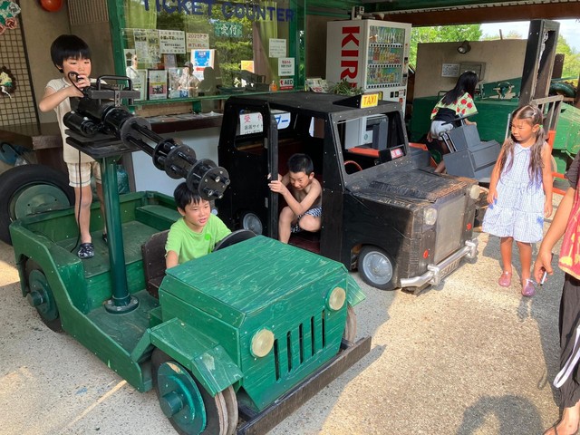 タクシーなどをかたどった遊具で遊ぶ子どもたち