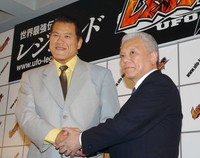 2002年６月、格闘技イベント「UFO LEGEND」の会見でアントニオ猪木さん（左）と握手を交わすイベントプロデューサー（当時）の川村龍夫さん