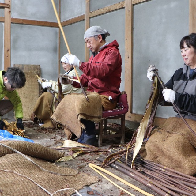 支援者らとコウゾの皮をむく良子さんの母（右端）ら