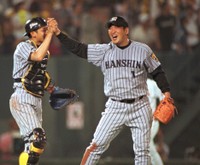 試合を締め、阪神・矢野燿大とタッチする阪神・中込伸＝2000年撮影