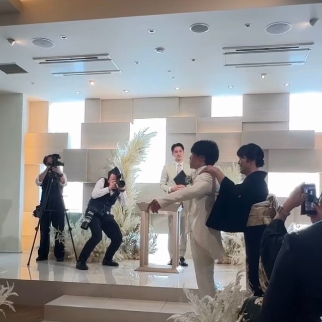 母にジャケットを着せてもらう新郎／たくまさん（@oya_taku0714）提供