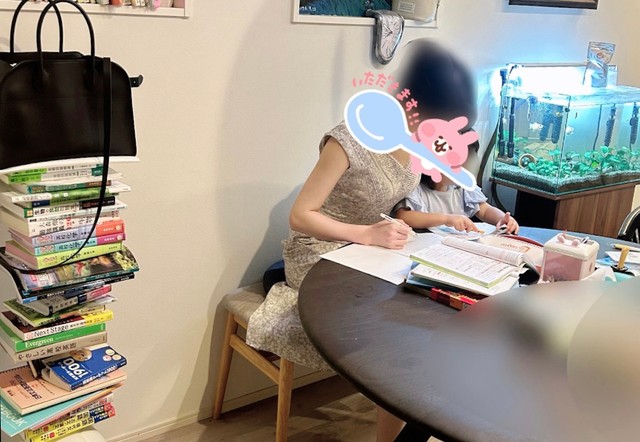 娘さんと並んで一緒に勉強中、左には参考書も積み上げられています（提供：むぎナスさん）