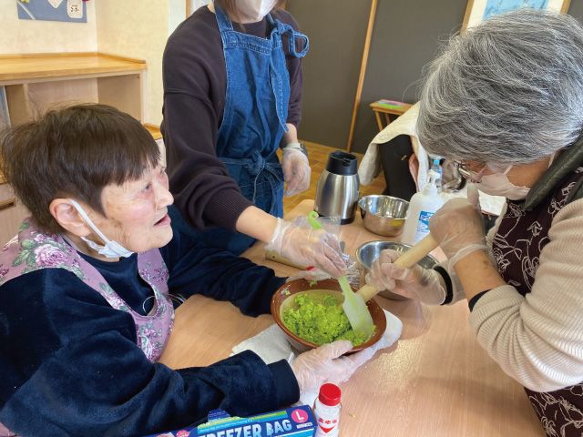 協力しながら枝豆をつぶしてずんだあんを作ります