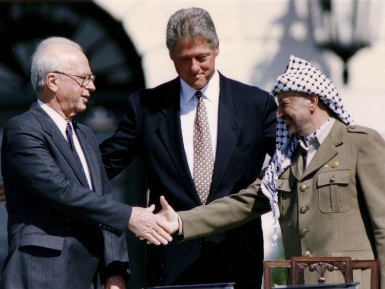 米ホワイトハウスで1993年9月13日、オスロ合意に署名後、クリントン米大統領（当時）を挟んで、握手をするイスラエルのラビン首相（同、左）とPLO（パレスチナ解放機構）のアラファト議長（同、右）＝ロイター
