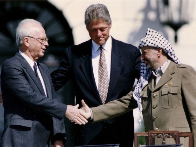 米ホワイトハウスで1993年9月13日、オスロ合意に署名後、クリントン米大統領（当時）を挟んで、握手をするイスラエルのラビン首相（同、左）とPLO（パレスチナ解放機構）のアラファト議長（同、右）＝ロイター
