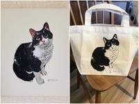 肖像画にはそれぞれのにゃんこ紹介も。この子は音楽仲間のクロスケ。闘病生活を送り１２歳で亡くなったという。飼い主いわく「ともに過ごした１２年は、愛に溢れた幸せな日々でした」（左）、絵と同じ図版が印刷されたトートバッグのおまけつき（右）