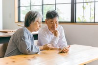 スマホを見て悩む夫婦※画像はイメージです（buritora/stock.adobe.com）