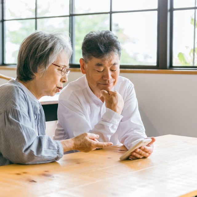 スマホを見て悩む夫婦※画像はイメージです（buritora/stock.adobe.com）