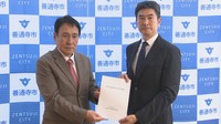 検討委員会の片山昭彦会長（右）が善通寺市の辻村市長（左）に報告書を提出