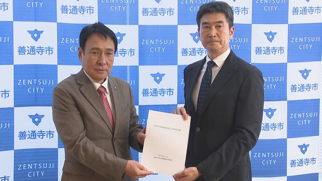 検討委員会の片山昭彦会長（右）が善通寺市の辻村市長（左）に報告書を提出