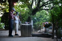 原爆投下から76年を迎えた朝、原爆供養塔に手を合わせる人たち＝2021年8月6日午前5時59分、広島市中区、金居達朗撮影