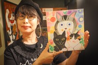 キムラさん。手に持っている色紙は、愛猫のチハトマ、牡丹を抱っこしている自分を描いた