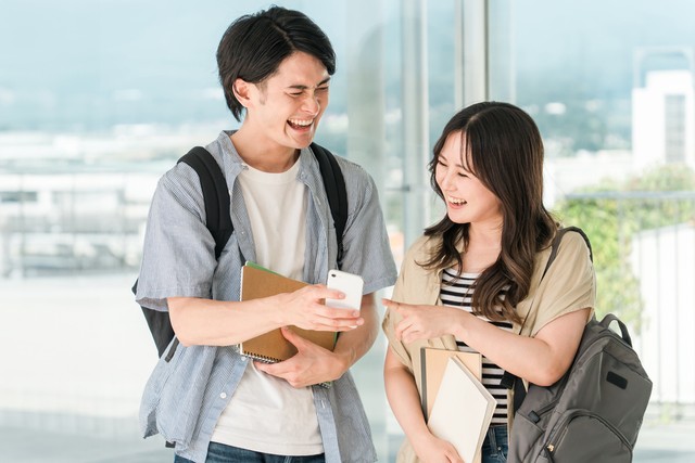 動画を見て笑う学生の男女※画像はイメージです（buritora/stock.adobe.com）