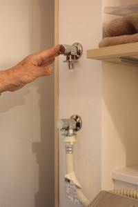 上水道の蛇口（下）からホースをつなぎかえることで、ためた雨水を洗濯に利用できる

