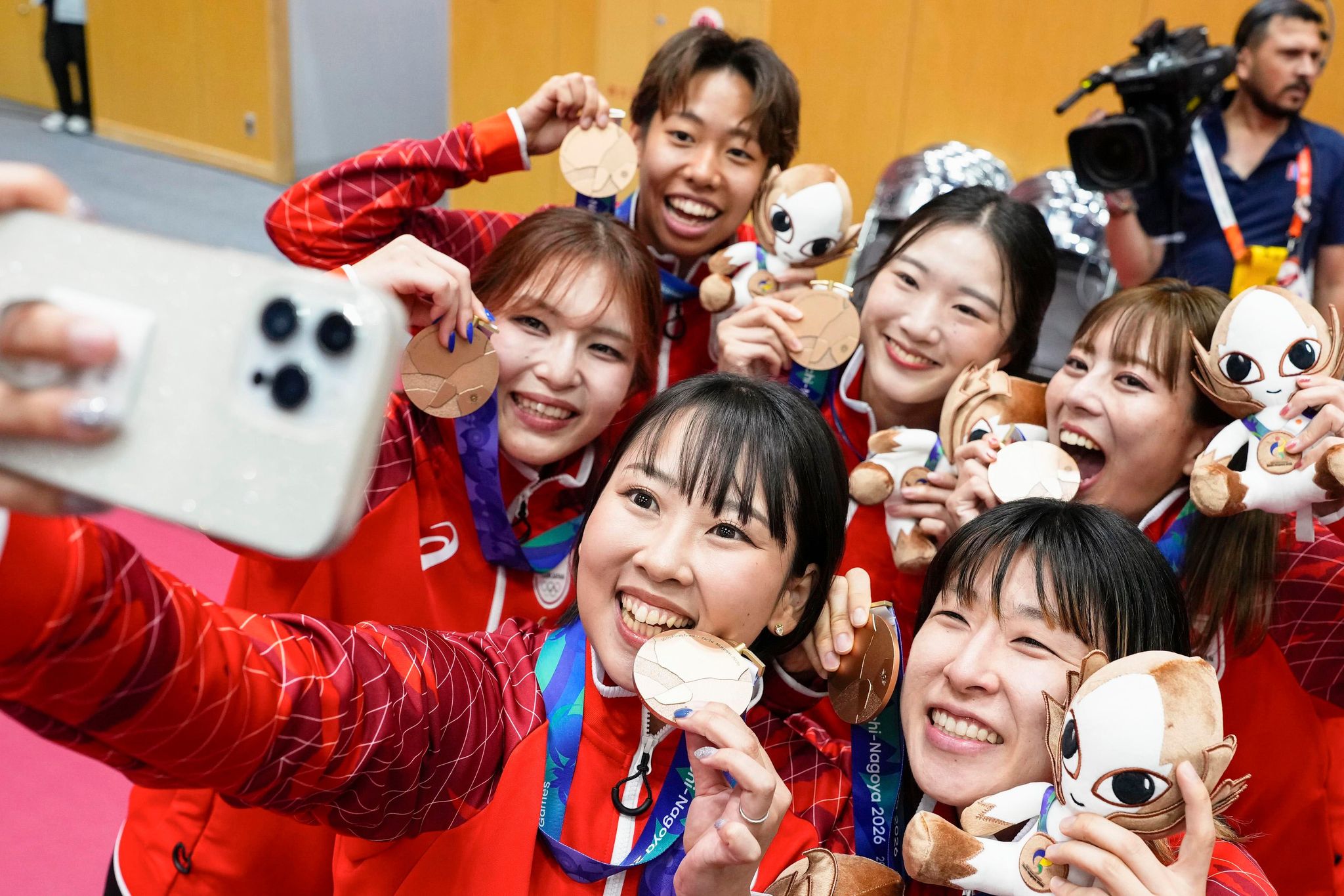愛知・名古屋アジア大会のセパタクロー女子クワッドで銅メダルを獲得し、笑顔で自撮りする伊沢千夏(前列中央)ら選手たち＝3日、パロマ瑞穂アリーナ