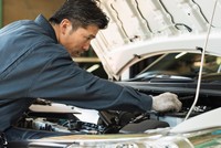 エンジンルームを点検する自動車整備士　※画像はイメージです（One/stock.adobe.com）