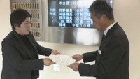 議長宛ての要請書を議会事務局長に手渡す植田真紀議員（左）
