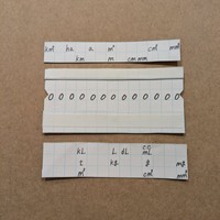 上部に面積の単位、長さ（距離）の単位、下部に「かさ」、重さ、体積の単位を書いたパーツを貼ります（提供：ぽんさん）