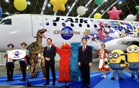 特別塗装機をお披露目したＵＳＪ副社長ＣＭＯ・村山卓氏（左から４番目）とＪＡＬ西日本地区支配人・武井真剛氏（同７番目）